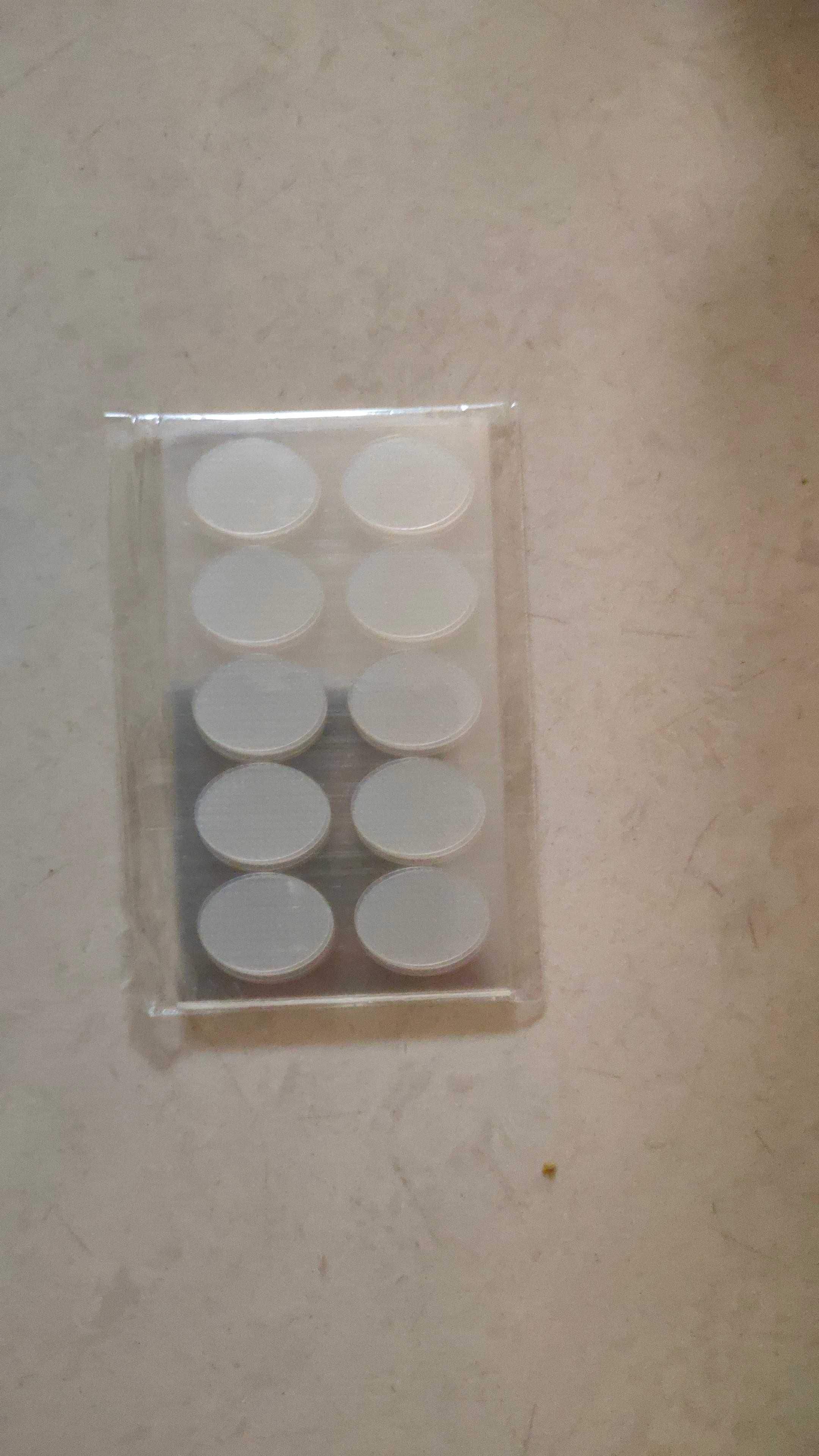Clear plastic packaging with round white objects on a beige surface