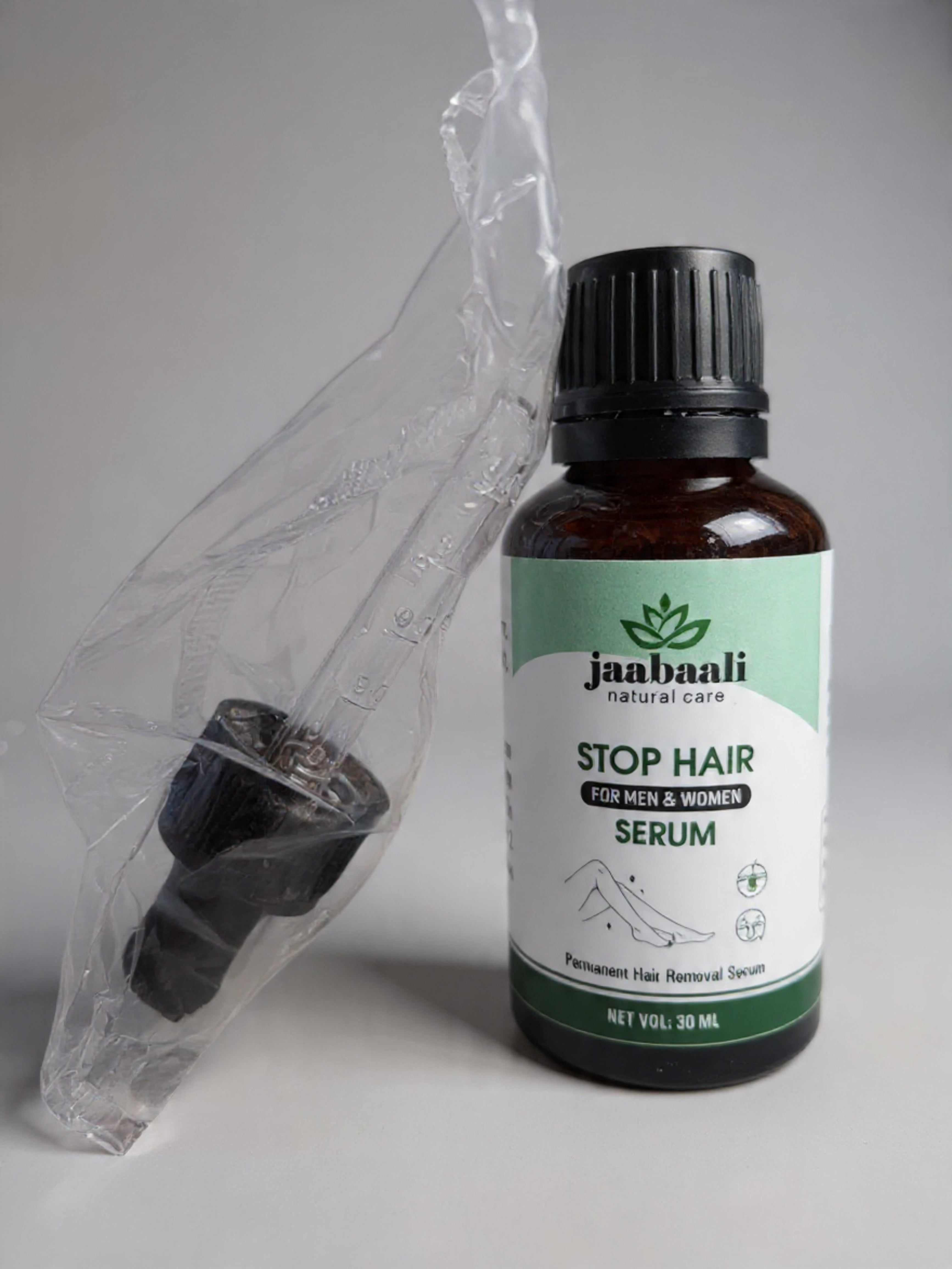 Bottle of Janbaali Stop Hair Serum with a clear plastic bag on a gray background