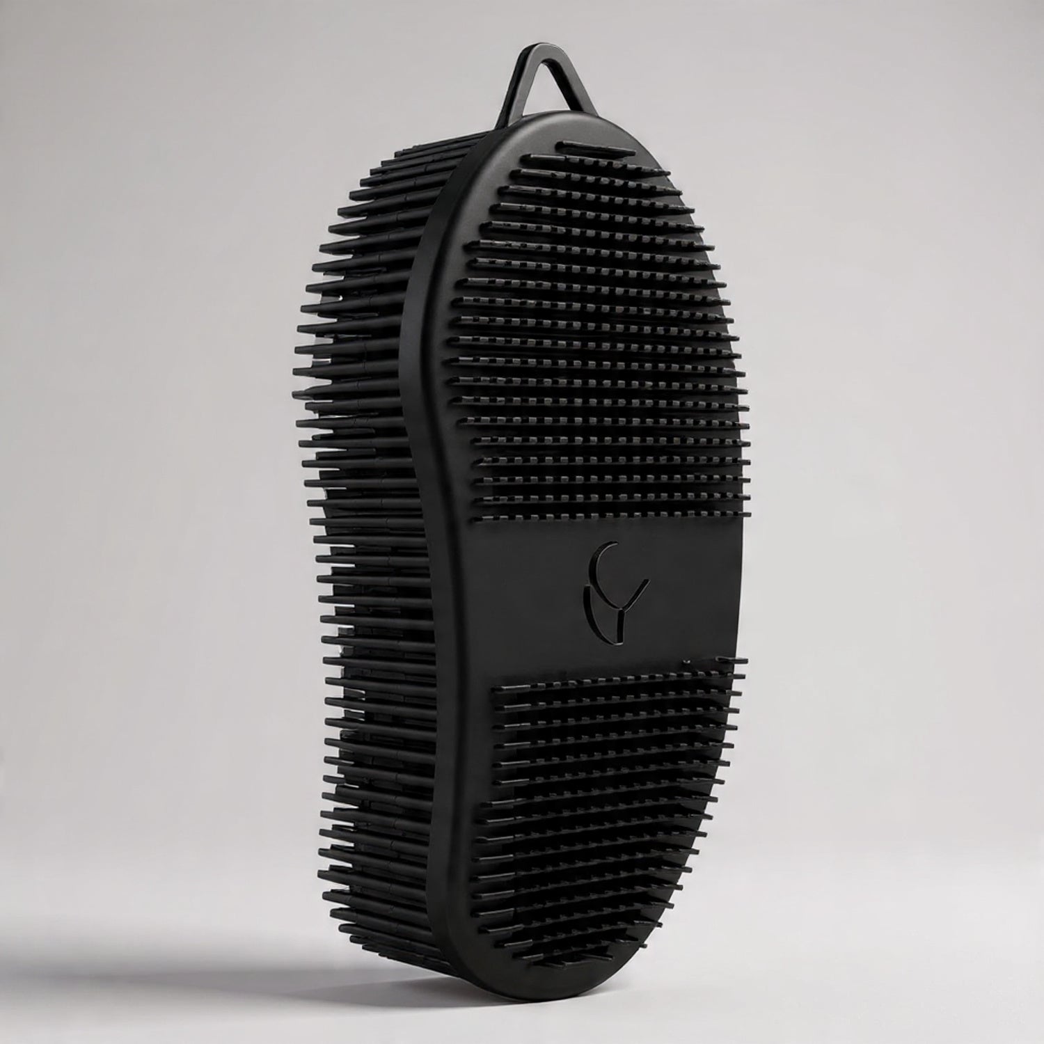 Black grooming brush on a light gray background