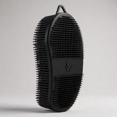 Black grooming brush on a light gray background